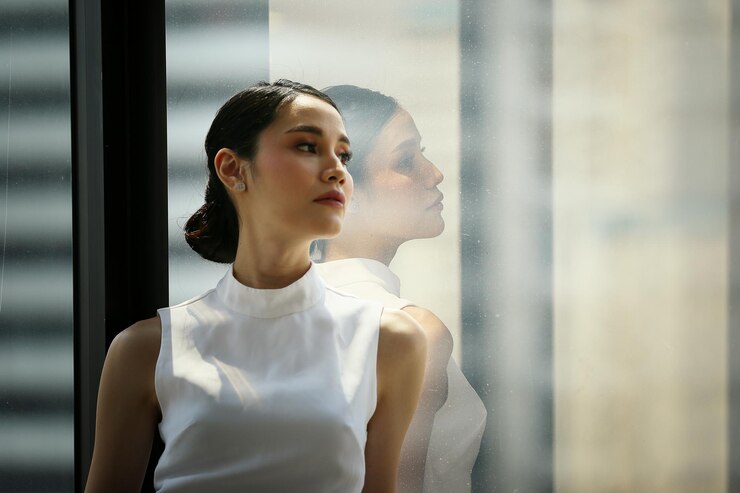 Photo 站在窗口旁邊的女商人