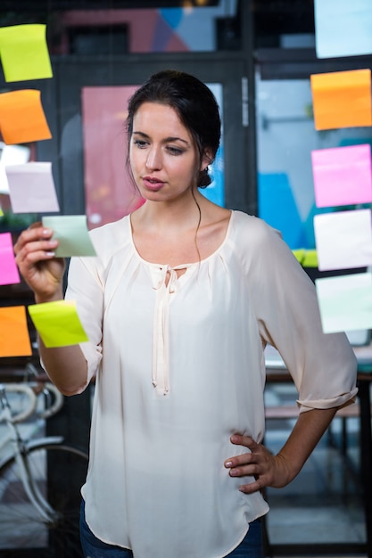 Businesswoman looking at sticky note