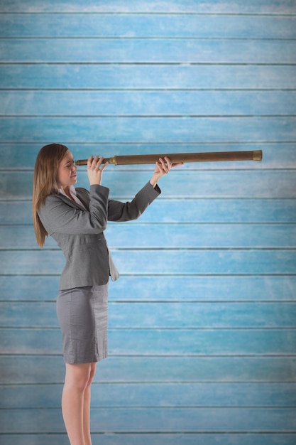 Businesswoman looking through a telescope against wooden planks