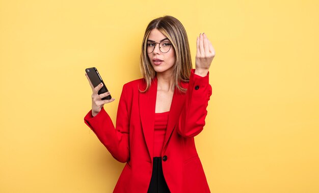 Businesswoman making capice or money gesture, telling you to pay. smartphone concept