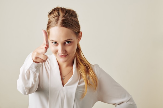 Businesswoman making hand gun gesture