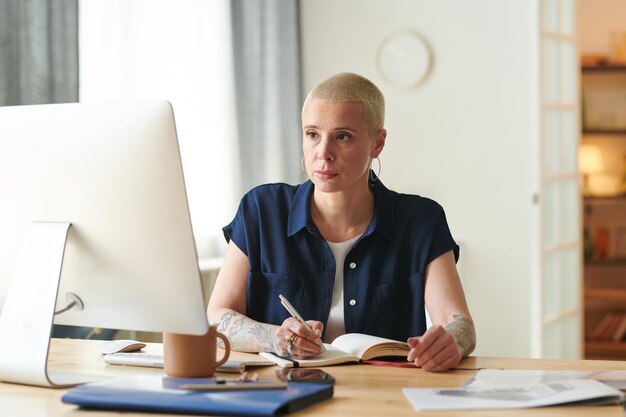 Businesswoman making notes during online conference