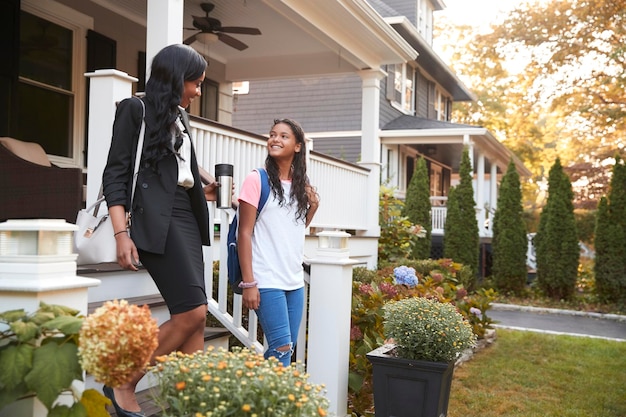 Businesswoman Mother Walking Daughter To School On Way To Work