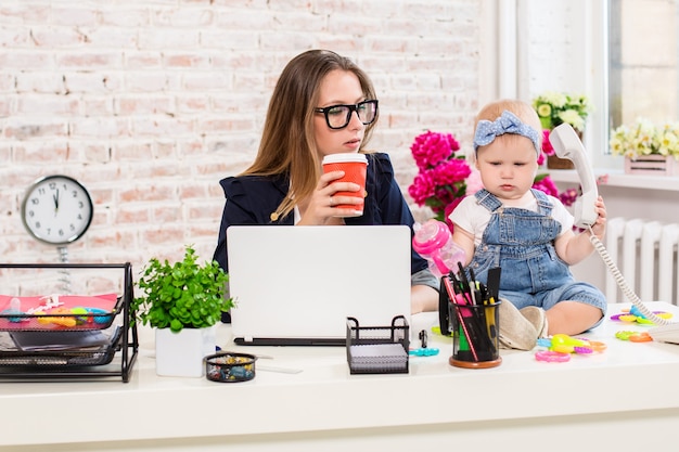 Photo businesswoman mother woman with a daughter working at the computer