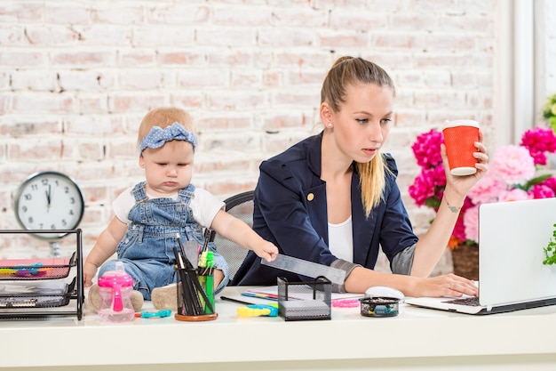 Photo businesswoman mother woman with a daughter working at the laptop