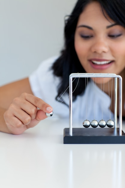 Photo businesswoman moving kinetic balls