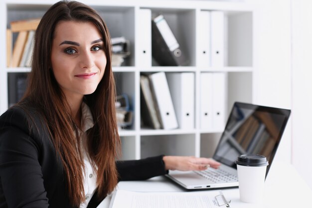 Businesswoman in the office holds her hand on the laptop