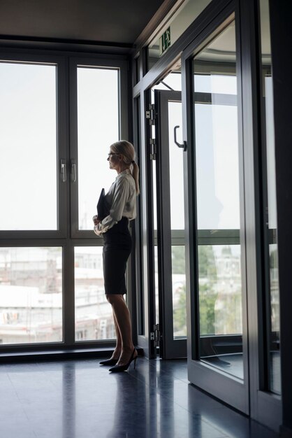 Businesswoman in office looking out of window