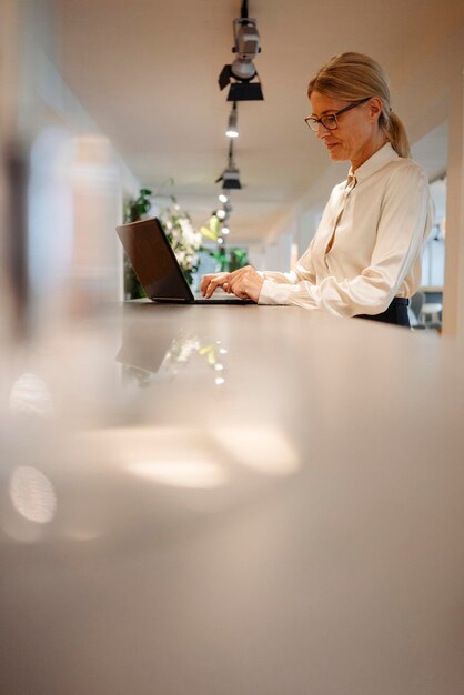 Businesswoman in office using laptop