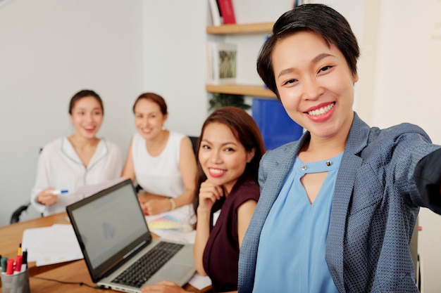 Photo businesswoman photographing with team