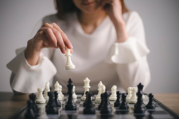 Businesswoman plays with chess game. concept of business strategy and tactic. strategy, management, or leadership concept