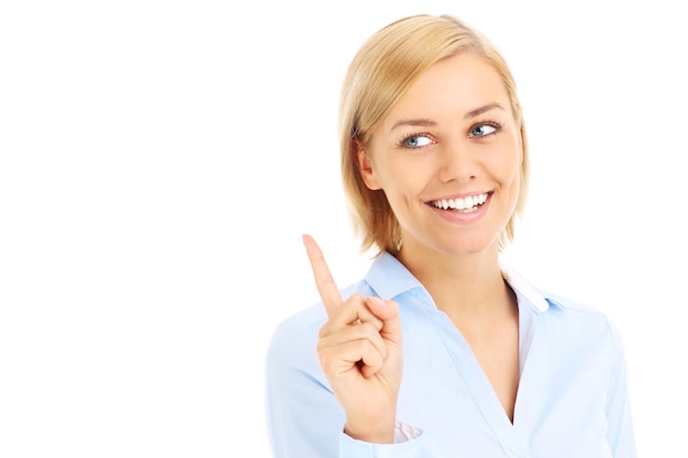 Businesswoman pointing on something over white background