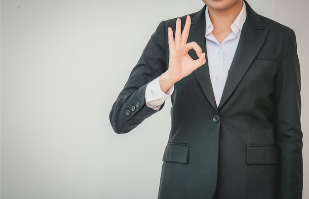 Businesswoman pointing up ok hand sign