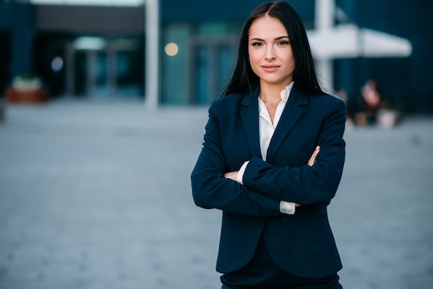 Businesswoman poses against business center