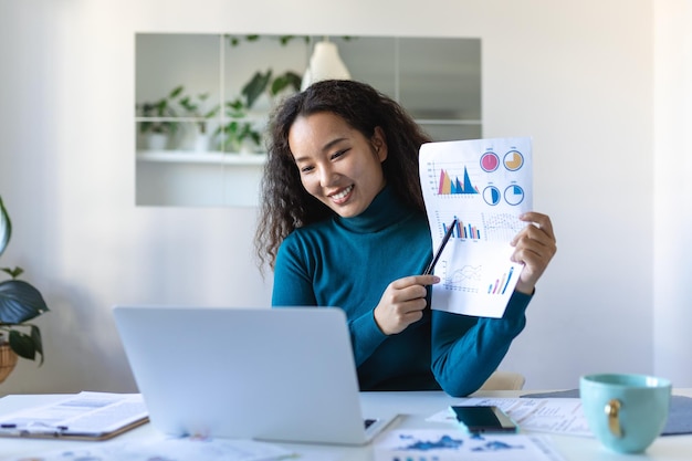 Businesswoman presenting charts and graphs on video call online Asian Business woman having conference call with client on laptop Closeup business woman working laptop computer indoor