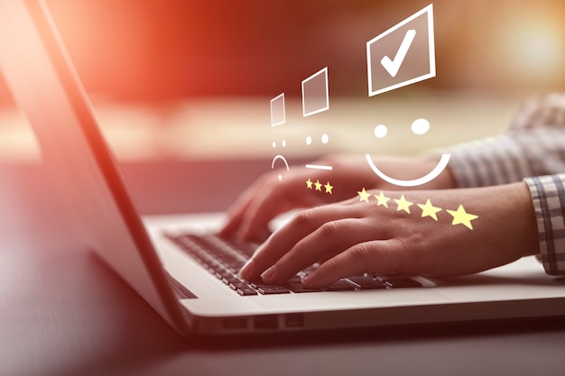 Businesswoman pressing smiley on keyboard laptop .customer service evaluation concept