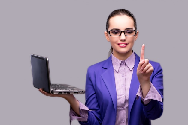 Donna di affari che preme il computer portatile virtuale della tenuta del bottone