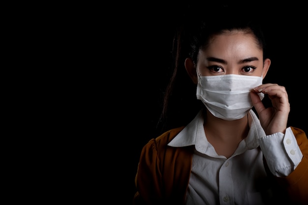 Businesswoman putting on a respirator N95 mask