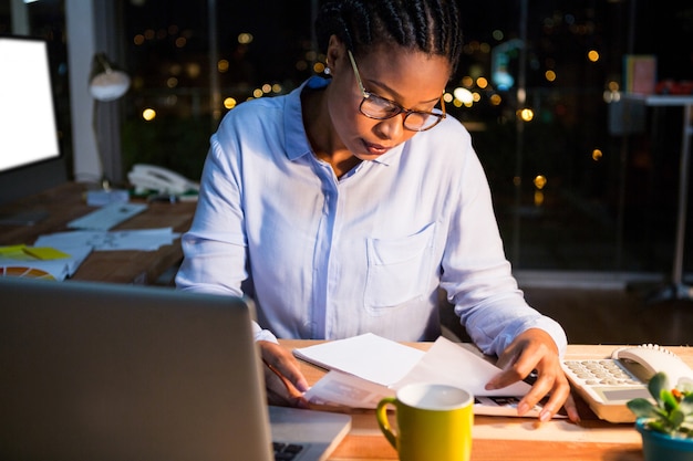 Businesswoman reading document at her desk