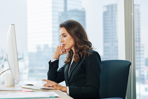 Businesswoman reading report on computer