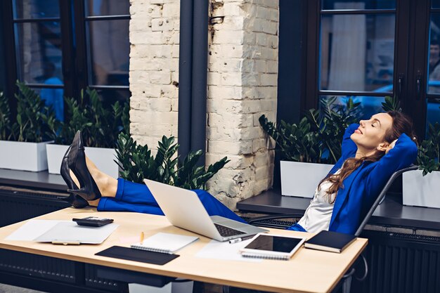 businesswoman relaxing on chair in office