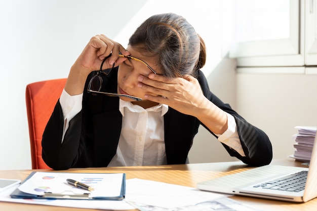 Businesswoman resting by closing eye while working in office.