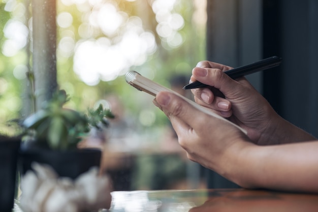 a businesswoman's hand working and holding a white blank notebook with screwed up papers o