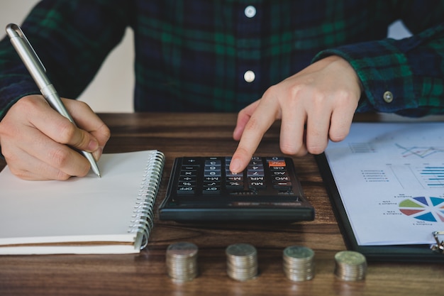 Businesswoman saving money and analyzing financial accounts on desk.