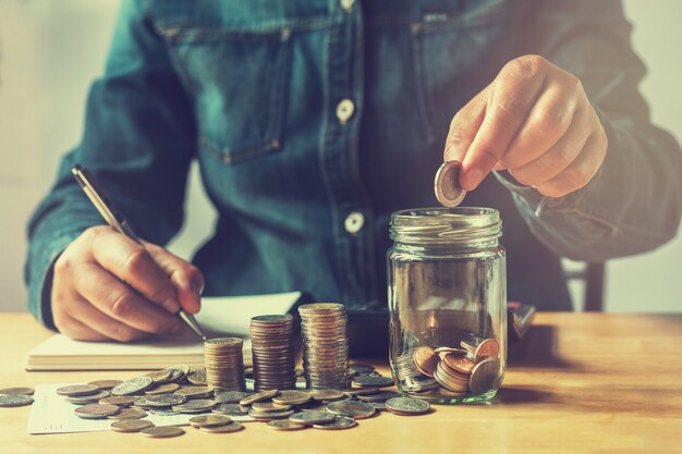 businesswoman saving money with putting coins in glass, finance accounting concept