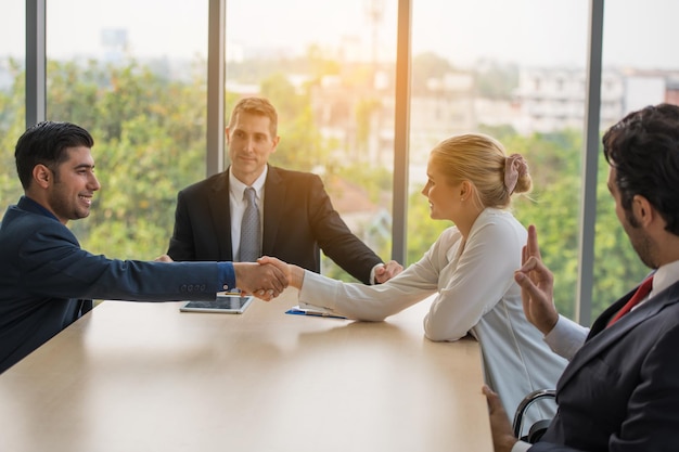 Businesswoman shaking hand with colleague in office