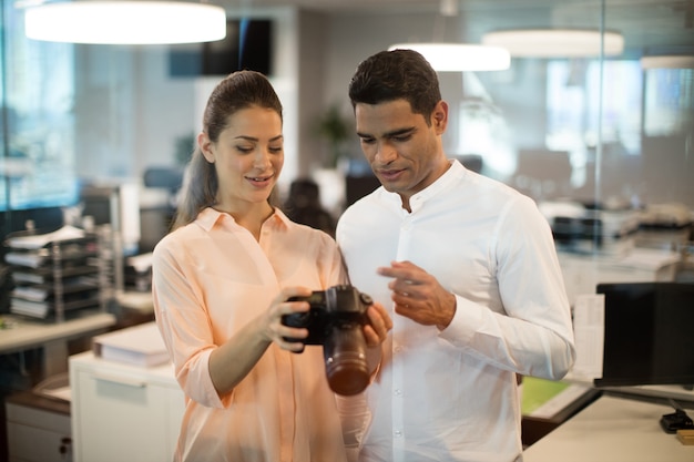 Businesswoman showing camera to colleague in office