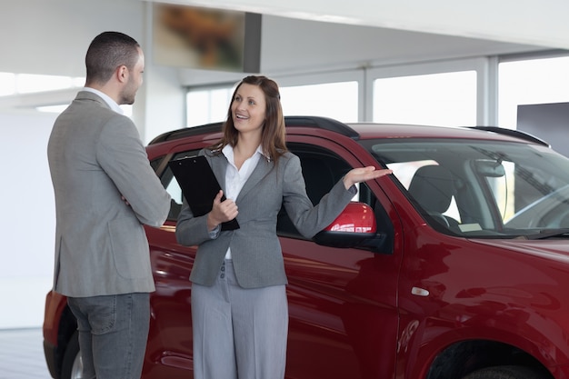 Businesswoman showing a car to a client