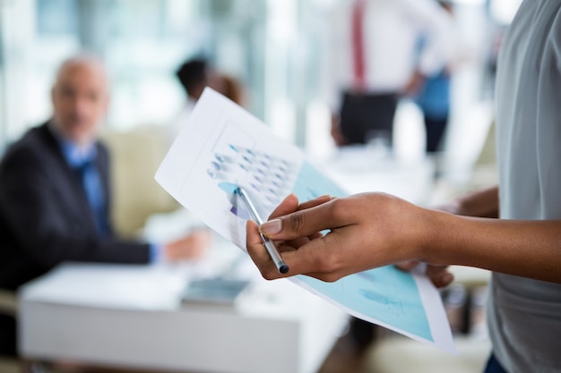 Businesswoman showing chart at office