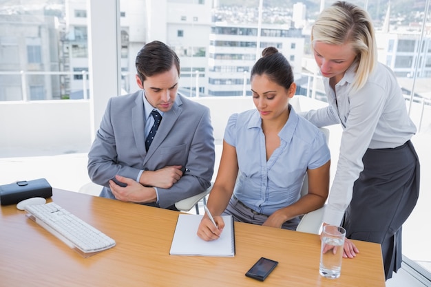 Businesswoman showing colleagues something on her notepad