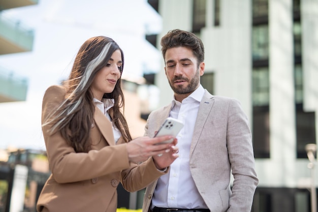 Businesswoman showing her smartphone to a colleague