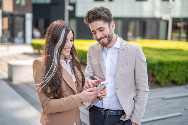 Imprenditrice che mostra il suo smartphone a un collega