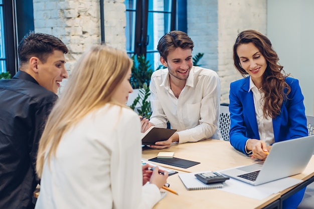 Businesswoman showing on laptop to colleagues