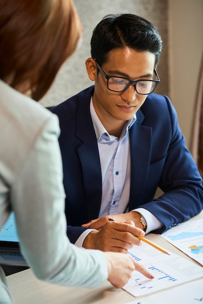 Businesswoman showing report to coworker