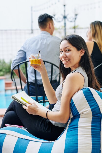 Businesswoman sitting by swimming pool