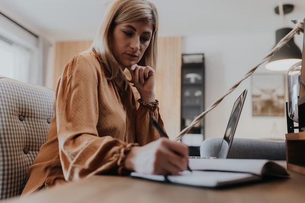 Businesswoman sitting in a chair and managing her business via home office 