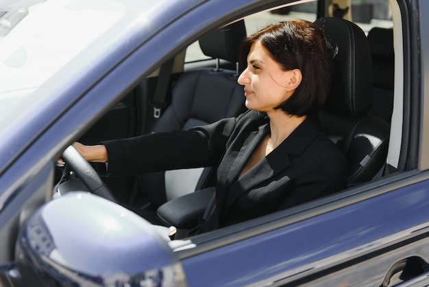 Foto donna di affari che si siede nel sedile del conducente nella sua auto