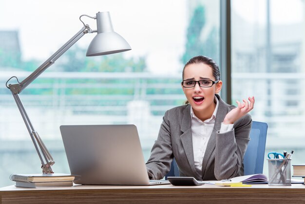 Businesswoman sitting at her desk in business concept