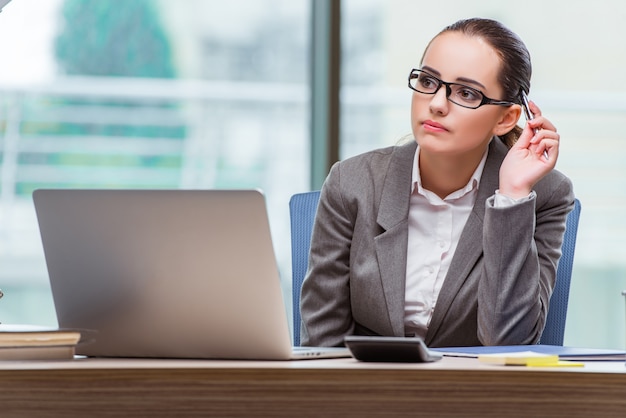 Businesswoman sitting at her desk in business concept