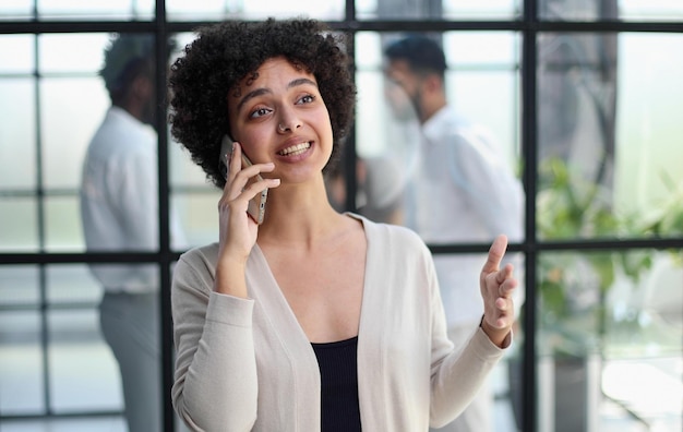 Businesswoman sitting in office talking on the phone