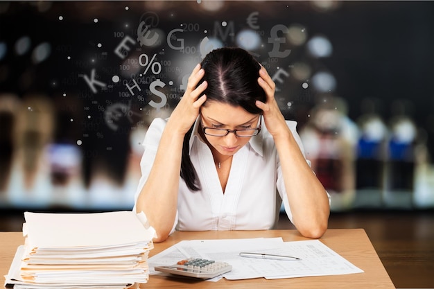 Photo businesswoman sitting at the table with many papers in office