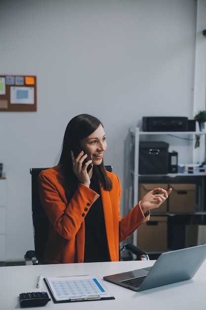 Businesswoman smile got good news on smartphone while working on computer