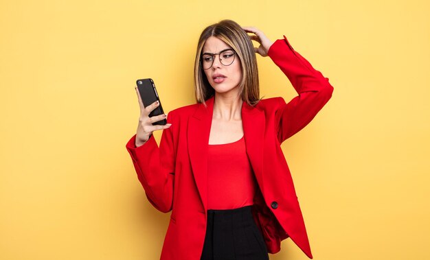 Businesswoman smiling happily and daydreaming or doubting. smartphone concept