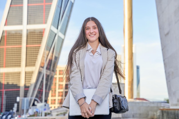 Businesswoman smiling with laptop in hand