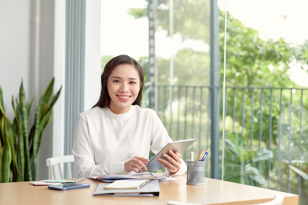 Businesswoman smiling and working on tablet computer