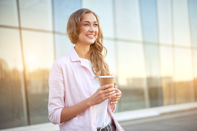 Businesswoman standing summer day near corporate building  Business person